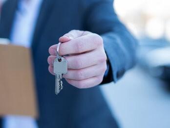 A,Real,Estate,Agent,Hands,Over,The,Key,For,An