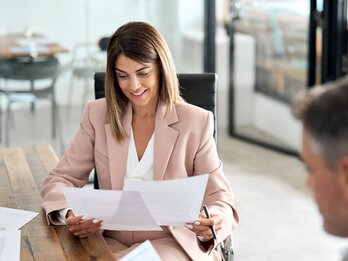 Bild Gesprächssituation mit Dokumenten zwischen Frau und Mann